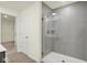 Modern bathroom with glass-enclosed shower, neutral tile, wood-look floor, and access to closet at 2750 Glade Ave, Plainfield, IN 46168