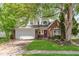 Charming home featuring a brick facade, well-maintained lawn, mature trees, and a two-car garage at 2916 Sunmeadow Way, Indianapolis, IN 46228