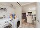 Functional laundry room with modern washer and dryer, shelving, and access to the kitchen at 2916 Sunmeadow Way, Indianapolis, IN 46228
