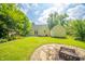 Lovely backyard with lush green lawn, firepit area, and beautiful foliage around the home at 311 Northshore Blvd, Anderson, IN 46011