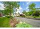Well-maintained home with a detached garage and a long gravel driveway, framed by lush greenery at 311 Northshore Blvd, Anderson, IN 46011