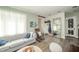 Comfortable living room with light gray sofa, wood floors, and decorative mirror reflecting the light from the window at 311 Northshore Blvd, Anderson, IN 46011