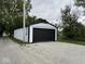 Detached garage, featuring ample space and a black door, complemented by a gravel driveway at 317 W Pierson St, Greenfield, IN 46140