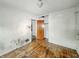 Shows a bedroom with hardwood floors, white walls, closet space, and a view into another room at 3615 N Dequincy St, Indianapolis, IN 46218