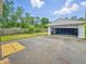 Detached garage with an open door and parking space in a backyard with a partial fence at 3615 N Dequincy St, Indianapolis, IN 46218