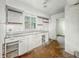 A kitchen view showcasing outdated cabinetry, sink, and peeling paint, needing remodel to improve aesthetic appeal at 3615 N Dequincy St, Indianapolis, IN 46218