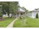 Quaint two-story home featuring a covered front porch and a mature tree in the front yard at 364 S Cole St, Indianapolis, IN 46241