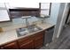 A stainless steel kitchen sink and faucet with wooden cabinets and adjacent dishwasher at 364 S Cole St, Indianapolis, IN 46241
