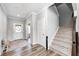 Bright foyer with a white door, hardwood floors, an open doorway, and staircase with carpeted steps at 3667 Gilmore Pl, Bargersville, IN 46106