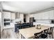 Open Kitchen and dining area features all white cabinets, an island with seating, and modern appliances at 3667 Gilmore Pl, Bargersville, IN 46106