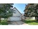 Charming two-story house with a two car garage, well-manicured lawn, and mature trees at 3959 Towhees Dr, Indianapolis, IN 46237