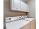 Clean laundry room with white cabinets and washer and dryer units at 3959 Towhees Dr, Indianapolis, IN 46237
