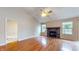 Inviting living room with hardwood floors, a cozy fireplace, and large windows offering scenic backyard views at 3959 Towhees Dr, Indianapolis, IN 46237