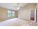 Bright main bedroom featuring a large window allowing natural light and soft, neutral colored carpet at 3959 Towhees Dr, Indianapolis, IN 46237