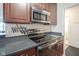 Modern kitchen with stainless steel appliances and sleek countertops with wooden cabinets at 3965 N Meridian St # 3J West, Indianapolis, IN 46208