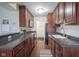 Galley kitchen equipped with stainless steel appliances, dark wood cabinetry and countertops at 3965 N Meridian St # 3J West, Indianapolis, IN 46208