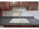 Close-up of a kitchen sink with dark countertops and wood cabinets at 3965 N Meridian St # 3J West, Indianapolis, IN 46208