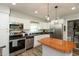 Well-lit kitchen featuring stainless steel appliances, white cabinets, black countertops and a center island at 4195 Locust Ln, Brownsburg, IN 46112