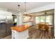 Open kitchen and dining area with stainless steel refrigerator, white cabinets, and wood dining table at 4195 Locust Ln, Brownsburg, IN 46112