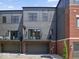 View of townhome with a gray facade, a brick element, and a two car garage at 420 Monon Wy Dr, Carmel, IN 46032