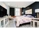 Modern bedroom featuring exposed brick, window, hard floors, dark accent wall and unique art at 430 N Park Ave # 211, Indianapolis, IN 46202