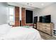 Bright bedroom featuring exposed brick, a queen bed, and a sleek dresser with a mirror at 430 N Park Ave # 211, Indianapolis, IN 46202