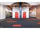 Lobby featuring two red elevator doors with exposed brick, wood beams, and modern carpet at 430 N Park Ave # 211, Indianapolis, IN 46202