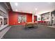 Large rec room with red accent wall, carpet, game table and a kitchenette at 430 N Park Ave # 211, Indianapolis, IN 46202
