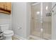 Clean bathroom featuring a glass-door shower and a classic toilet with a wooden storage cabinet at 450 E Ohio St # Apt 305, Indianapolis, IN 46204