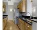 Kitchen features stainless steel appliances, black countertops, light wood cabinets, and hardwood floors at 450 E Ohio St # Apt 305, Indianapolis, IN 46204