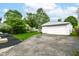 A view of a large garage with a wide driveway and mature trees in the background at 4751 Payton Ave, Lawrence, IN 46226