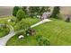Expansive aerial view of a red brick two-story home surrounded by lush green lawns, mature trees and outbuildings at 4817 N 150 W, Anderson, IN 46011
