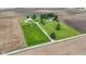 Aerial view of a large, verdant property featuring a two-story brick home, outbuildings, and surrounding farm land at 4817 N 150 W, Anderson, IN 46011