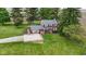 A lush lawn surrounds this traditional two-story home with red brick exterior, mature landscaping, and a charming front entry at 4817 N 150 W, Anderson, IN 46011