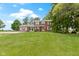 A well-maintained two-story red brick house features a lush green lawn and mature trees at 4817 N 150 W, Anderson, IN 46011