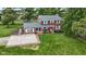 Aerial shot showcases a red brick two-story home with grey roof, brick-lined parking area, and well-manicured front yard at 4817 N 150 W, Anderson, IN 46011