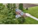 Aerial view of a two-story red brick home with a deck, manicured lawn, and mature trees on a sunny day at 4817 N 150 W, Anderson, IN 46011