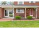 Charming front porch with brick flooring, lush greenery, and red brick exterior at 4817 N 150 W, Anderson, IN 46011