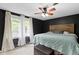Main bedroom featuring dark walls, carpeted floors, two large windows, and a wood headboard at 4817 N 150 W, Anderson, IN 46011