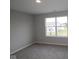 Neutral carpeted bedroom with a window overlooking an adjacent building at 4947 Amber Crest Dr, Brownsburg, IN 46112