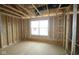 Unfinished new bedroom with a window, framing, and visible studs showcasing the construction phase at 4947 Amber Crest Dr, Brownsburg, IN 46112