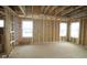 Unfinished living room with framing, three windows, and wiring showcasing the construction stage at 4947 Amber Crest Dr, Brownsburg, IN 46112