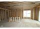 Unfinished living room with framing, wiring, and a window showcasing the construction phase at 4947 Amber Crest Dr, Brownsburg, IN 46112