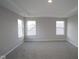 Spacious main bedroom with tray ceiling, large windows, and neutral carpet at 4947 Amber Crest Dr, Brownsburg, IN 46112