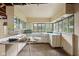 Vintage fixer-upper kitchen showcases retro cabinetry and large windows, offering abundant light and potential at 5035 Boulevard Pl, Indianapolis, IN 46208