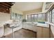 Spacious fixer-upper kitchen ready for renovation features retro cabinets and large windows for ample light at 5035 Boulevard Pl, Indianapolis, IN 46208