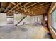 Spacious fixer-upper living room showcases potential with exposed beams, open staircase, and large picture window at 5035 Boulevard Pl, Indianapolis, IN 46208