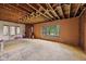Renovation-ready living room features exposed ceiling beams and a large window offering ample natural light at 5035 Boulevard Pl, Indianapolis, IN 46208