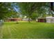 A large grassy yard features the red brick house and a shed at 5092 S 50 W, Anderson, IN 46013