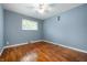 A bedroom features hardwood floors, a window, blue walls, and a vent at 5092 S 50 W, Anderson, IN 46013